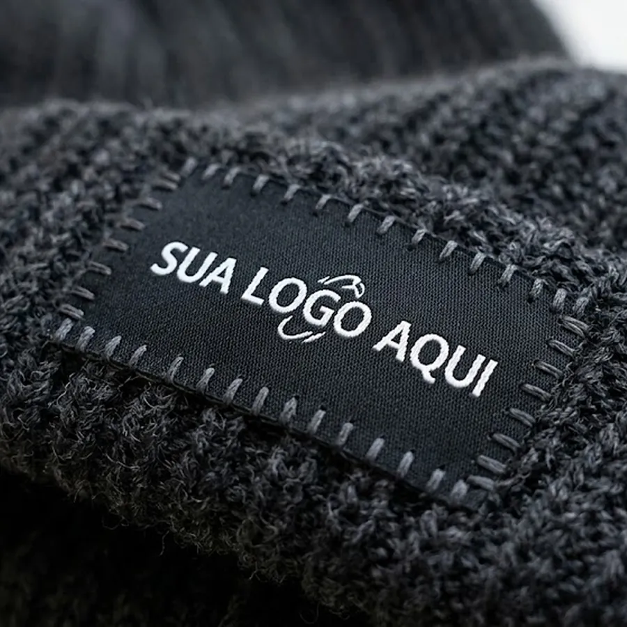 Etiqueta tecida preta costurada em gorro de tricô